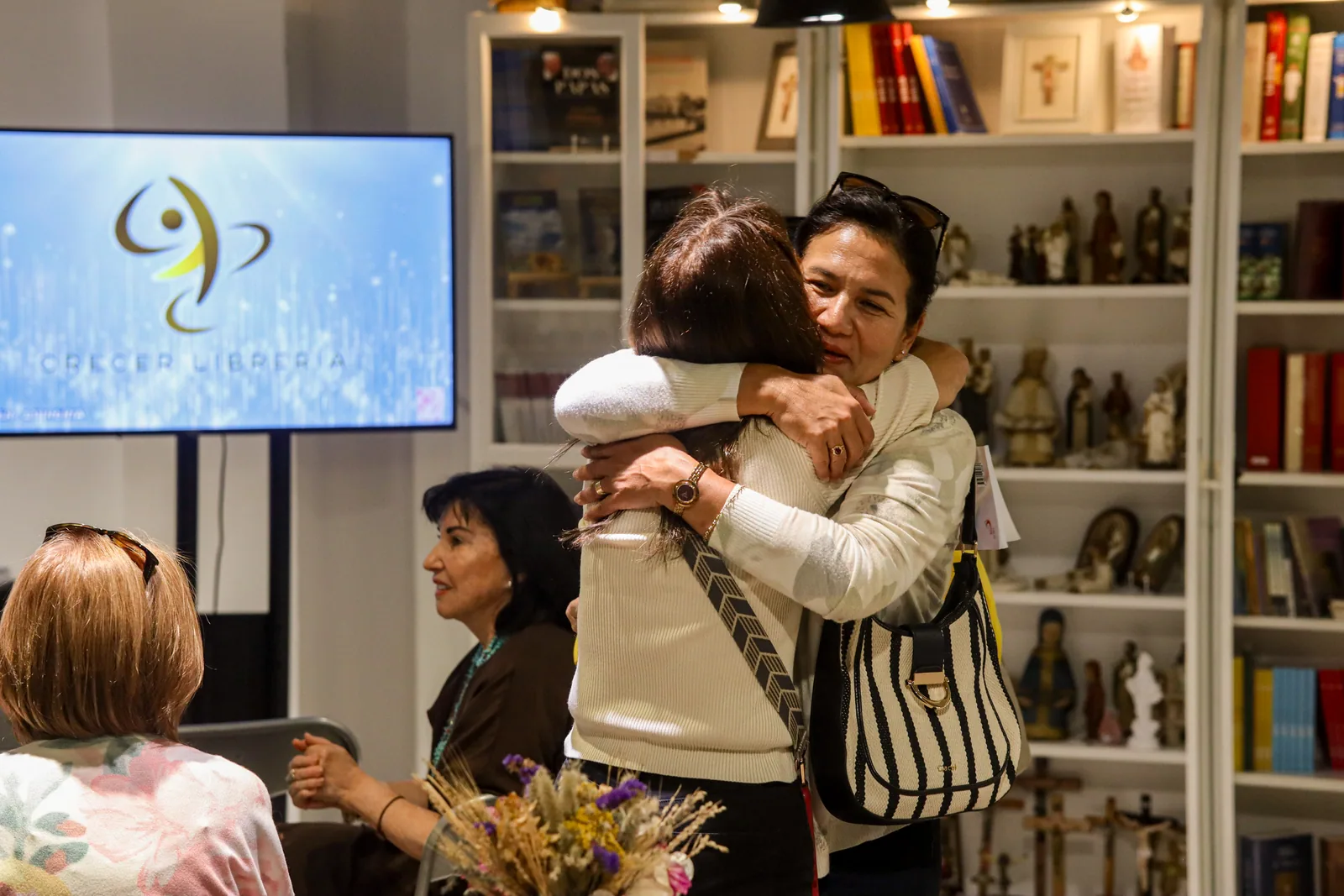 Abrazo entre asistentes de un encuentro de Librería Crecer